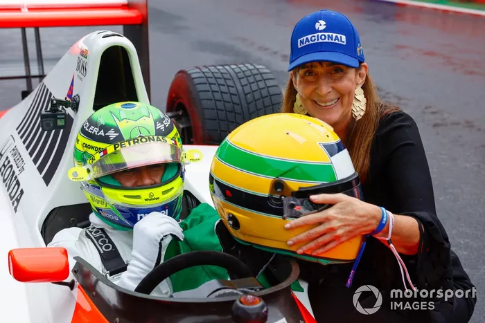 Lewis Hamilton in the cockpit of the McLaren MP4/5B, with Viviane Senna, sister of Ayrton Senna, holding her brothers helmet
