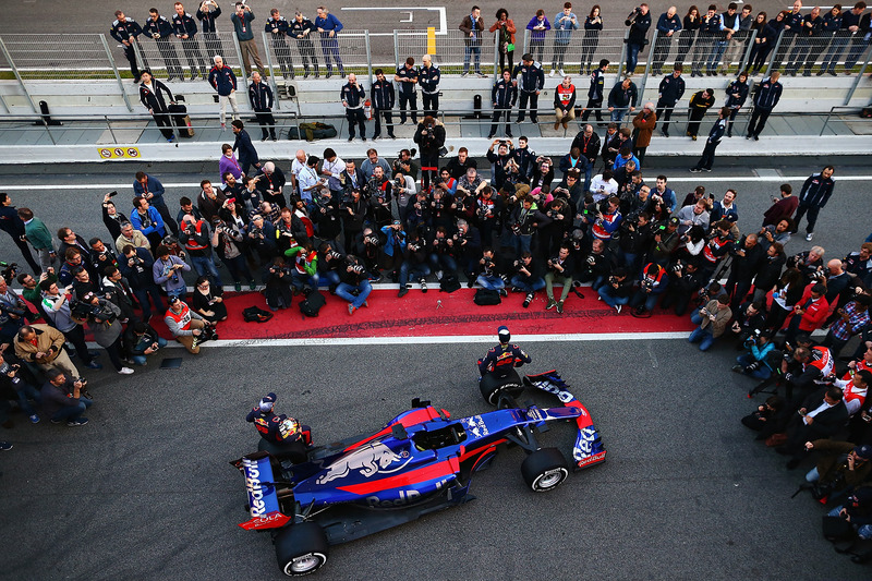 Гонщики Scuderia Toro Rosso Даниил Квят и Карлос Сайнс-мл. позируют рядом с автомобилем STR12