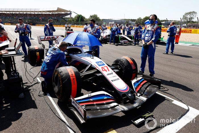 Mecánicos en la parrilla con el coche de Mick Schumacher, Haas VF-21