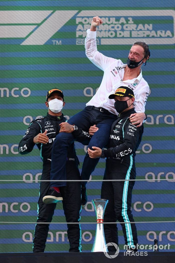 Lewis Hamilton, Mercedes, primera posición, el encargado de Mercedes de recoger el trofeo y Valtteri Bottas, Mercedes, tercera posición, en el podio