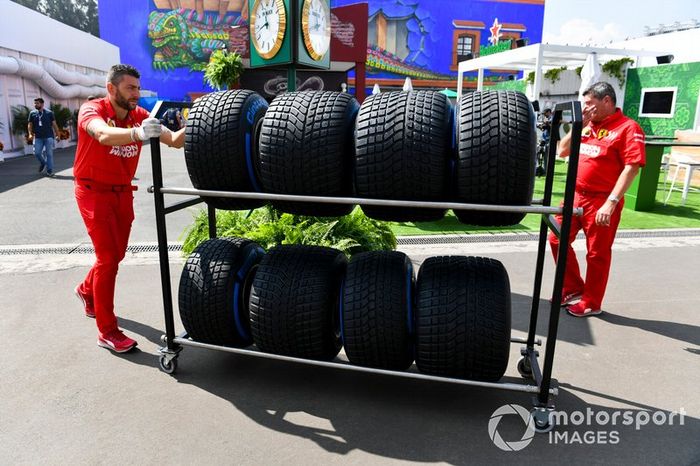 Mecánico de Ferrari con neumáticos Pirelli para lluvia en el paddock 