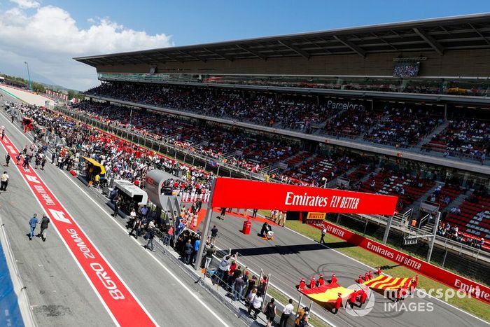 La parrilla con la Bandera de España y Cataluña durante el Himno Nacional