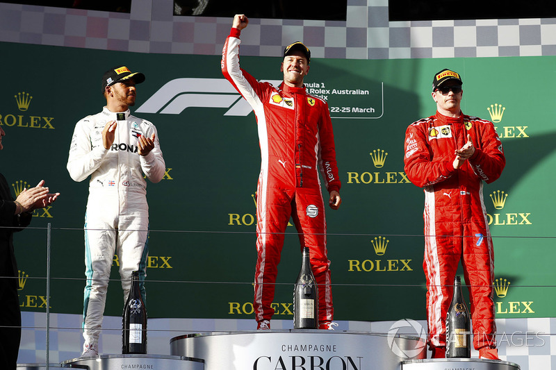 Sebastian Vettel, Ferrari, celebrates victory on the podium with second place Lewis Hamilton, Merced