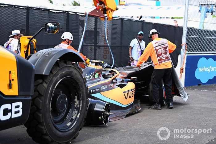 Los oficiales de pista retiran el coche dañado de Lando Norris, McLaren MCL36