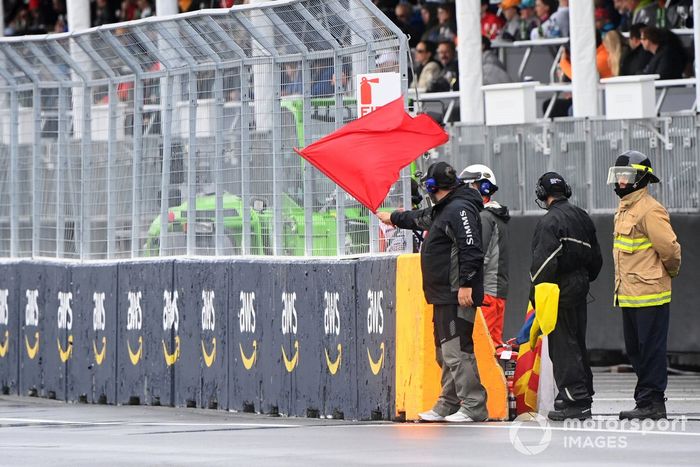 Oficiales de pista despliegan la bandera roja en la calificación