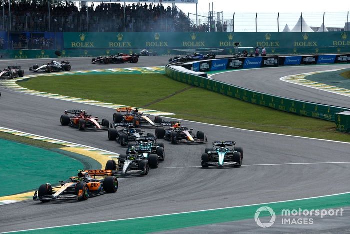 Lando Norris, McLaren MCL60, Lewis Hamilton, Mercedes F1 W14, Fernando Alonso, Aston Martin AMR23, el resto de la parrilla en la salida mientras Alex Albon, Williams FW45, Kevin Magnussen, Haas VF-23, chocan al fondo.
