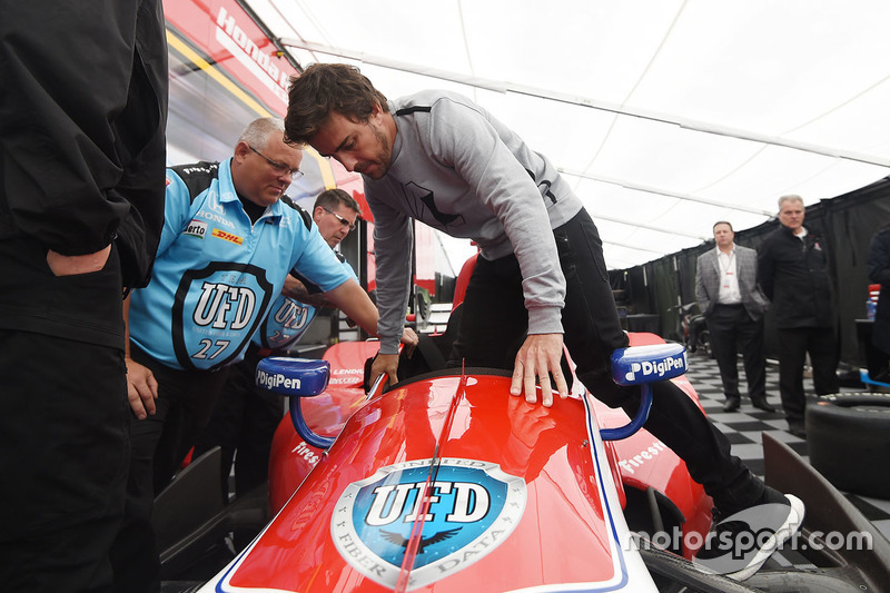 Fernando Alonso sits in the car of Marco Andretti