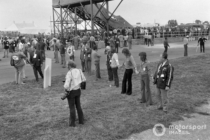 Los oficiales bloquean la pista al limpiarla después de una gran colisión en la primera vuelta