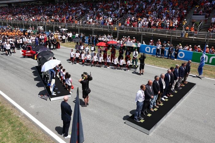 Pilotos, delegados oficiales y niños de la parrilla en la parrilla de salida