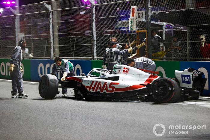 Los oficiales de pista recuperan los restos del coche dañado de Mick Schumacher, Haas VF-22, tras un fuerte accidente en la Q2  