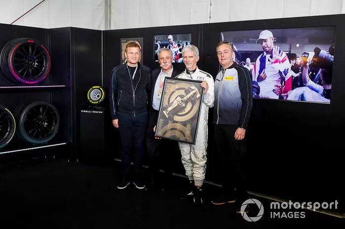 Chase Carey, presidente de Fórmula 1, Damon Hill y Mario Isola, gerente de carreras de Pirelli Motorsport, presentan el póster oficial de la carrera 1000 de F1