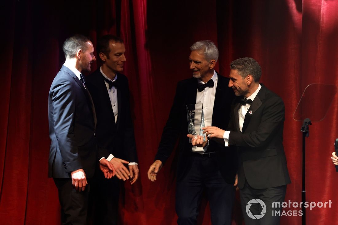 Andrea Stella, dyrektor zespołu McLaren F1 Team, i jego koledzy odbierają nagrodę International Competition Car of the Year dla Mercedesa McLaren MCL38, a Damon Hill przygląda się temu z boku.