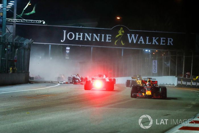  Daniel Ricciardo, Red Bull Racing RB13, passes Sebastian Vettel, Ferrari SF70H, as the latter crashes out