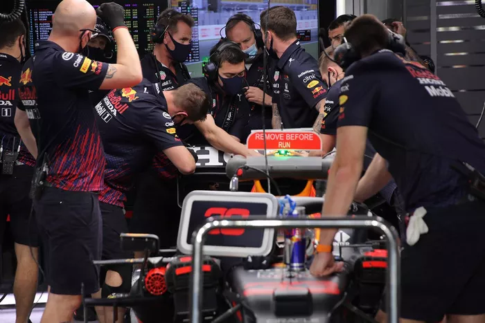 Miembros del equipo Red Bull Racing trabajando en el alerón trasero