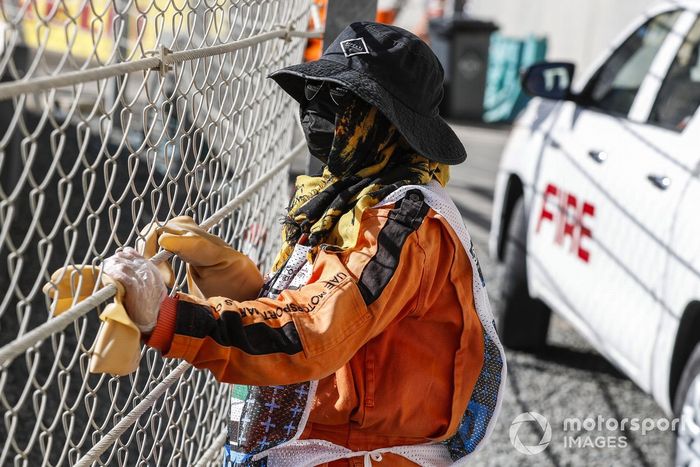 Un oficial de pista observa a través de la valla de seguridad