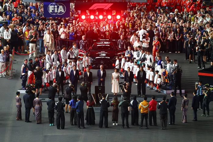  Drivers, official delegates, grid kids line up on the grid