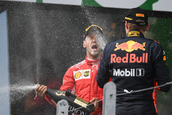 Race winner Sebastian Vettel, Ferrari and Max Verstappen, Red Bull Racing celebrate on the podium with the champagne