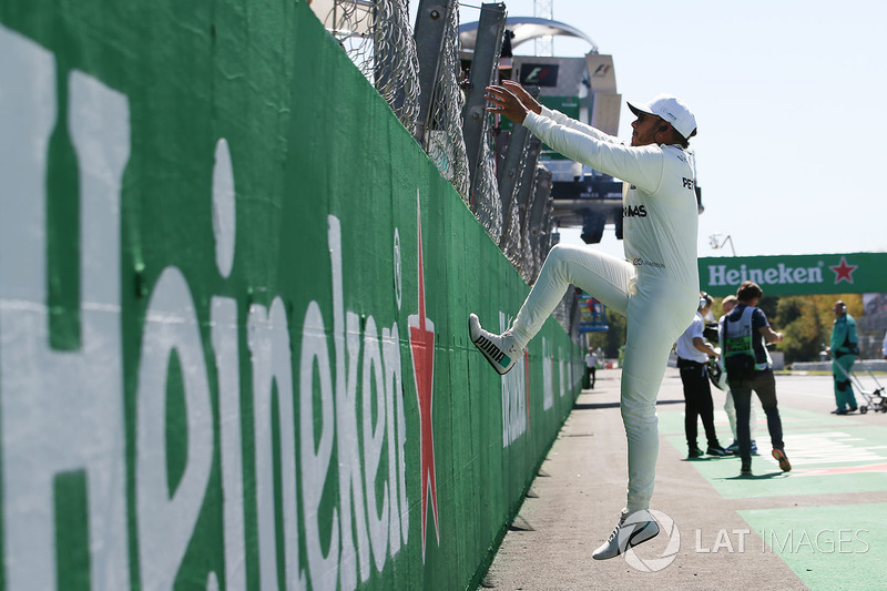 Race winner Lewis Hamilton, Mercedes AMG F1, climbs the pit wall