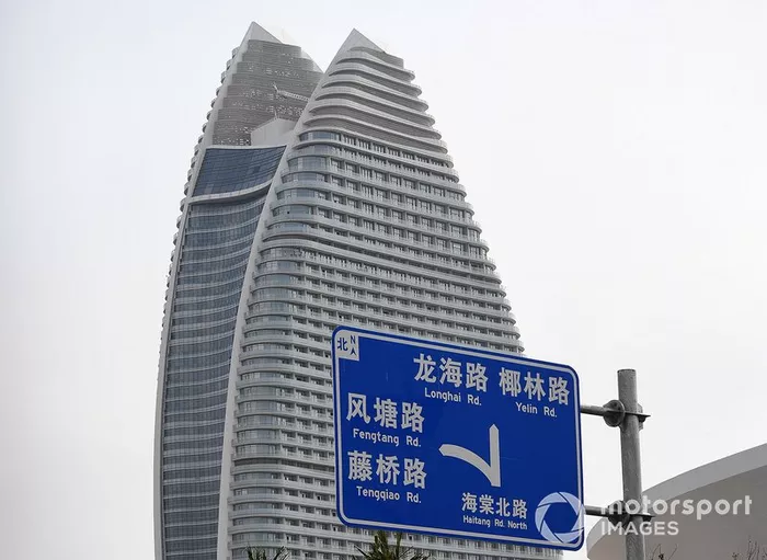 A road sign, a skyscraper in the background