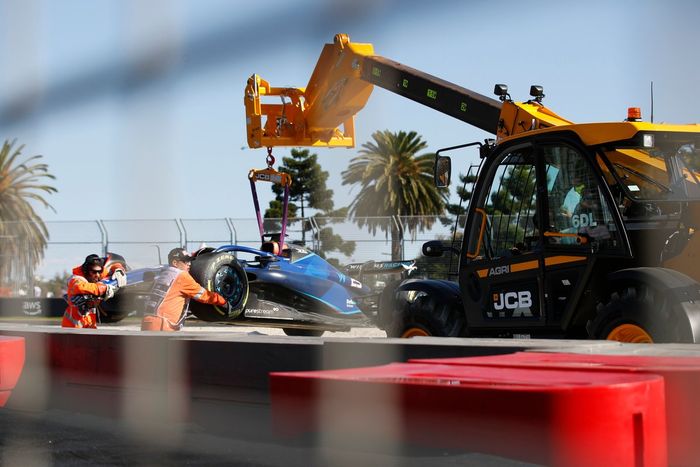 Oficiales de pista retiran del circuito el coche dañado de Alex Albon, Williams FW45