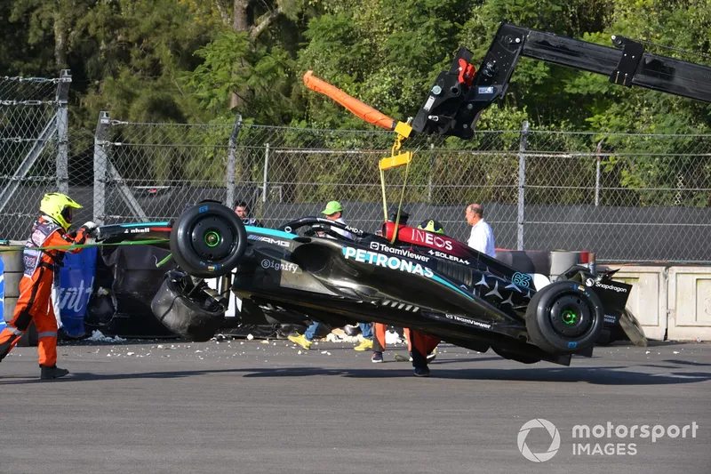 Des commissaires s'occupent de la voiture accidentée de George Russell, Mercedes F1 W15