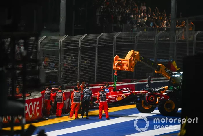 Los comisarios retiran el coche dañado de Carlos Sainz, Ferrari SF-24, del circuito