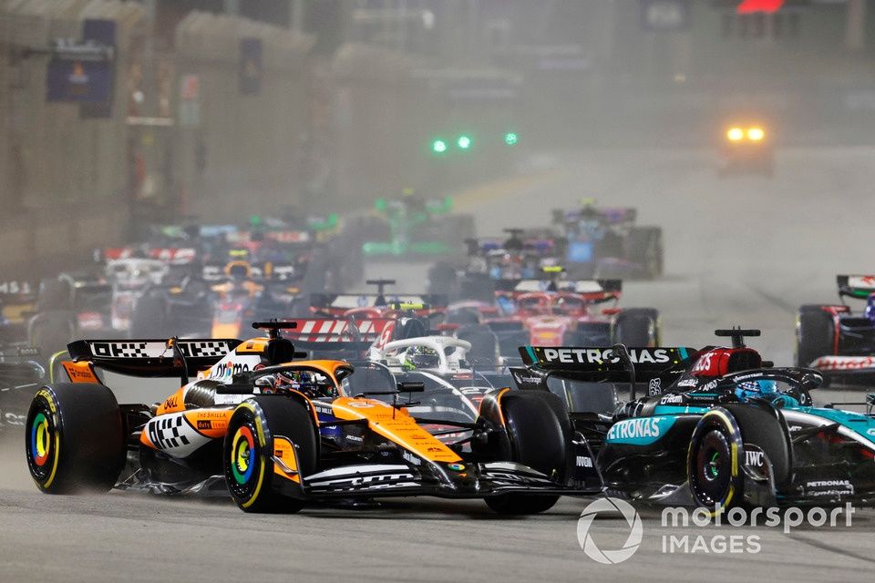 George Russell, Mercedes F1 W15, lucha con Oscar Piastri, McLaren MCL38, por delante de Nico Hulkenberg, Haas VF-24, Fernando Alonso, Aston Martin AMR24, el resto del pelotón en la salida.