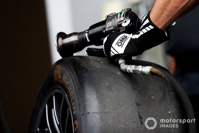 A mechanic prepares to put a wheel on a car