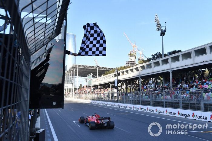 La bandiera a scacchi sventola alla fine della gara mentre passa Sebastian Vettel, Ferrari SF90, terzo