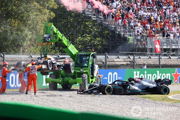 Los oficiales de pista retiran de la grava los coches de Max Verstappen, Red Bull Racing RB16B, y Lewis Hamilton, Mercedes W12