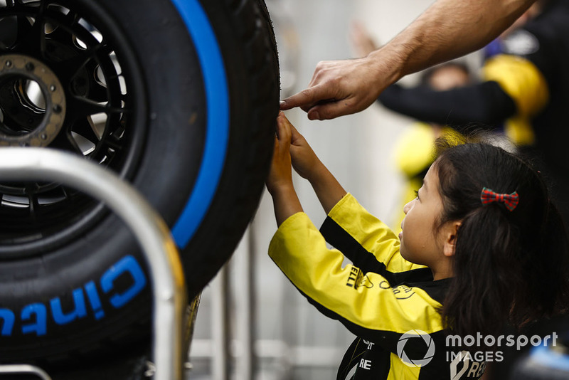 Young fans check out the Pirelli tyres of the Reanult team.