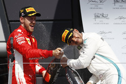 Sebastian Vettel, Ferrari, e Lewis Hamilton, Mercedes AMG F1, festeggiano sul podio con lo champagne