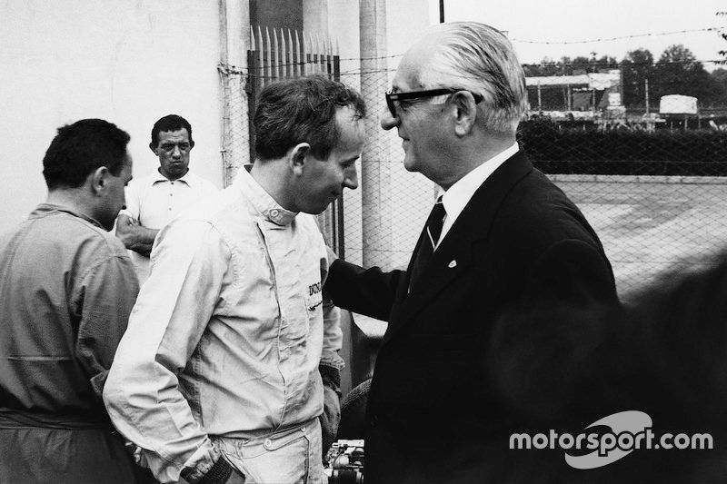 John Surtees con el jefe del equipo Ferrari Enzo Ferrari hablan en boxes