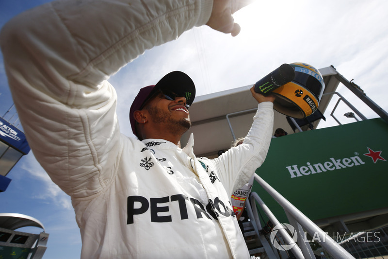 Гонщик Mercedes AMG F1 Льюис Хэмилтон показывает болельщикам подаренный ему шлем Айртона Сенны
