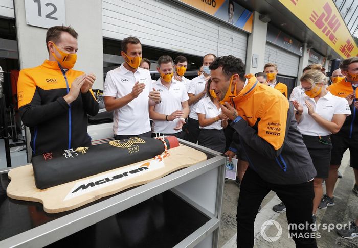 Lando Norris y miembros del equipo McLaren, con una tarta de cumpleaños de Daniel Ricciardo