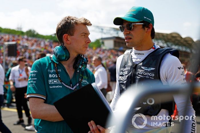 Lance Stroll, del equipo Aston Martin F1, habla con un ingeniero en la parrilla de salida