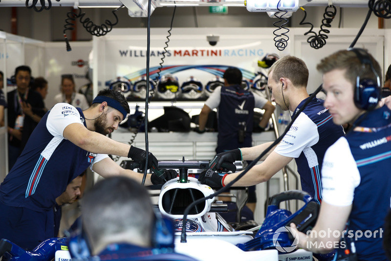Engineers work on the car of Lance Stroll, Williams FW41, in the garage