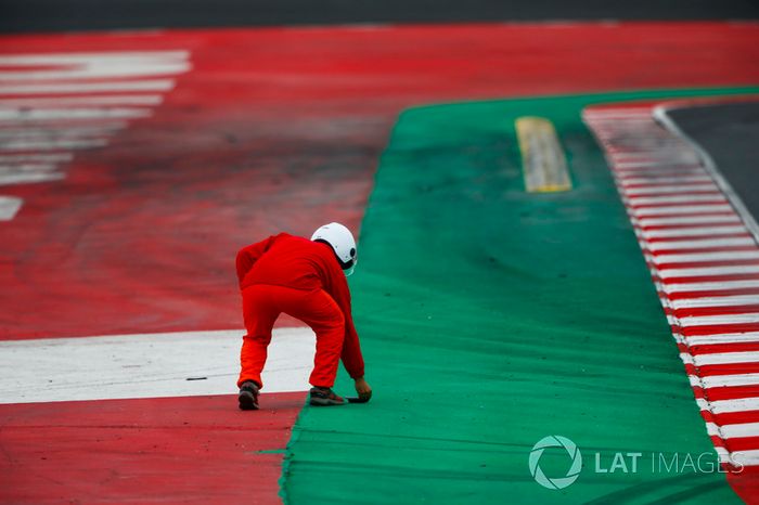Un oficial recoge un pedazo de escombros de la pista