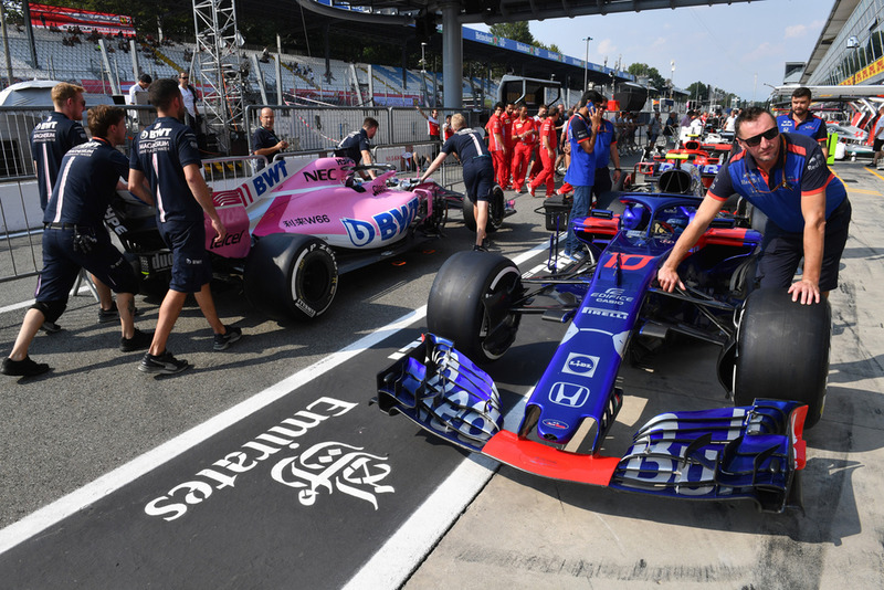 Toro Rosso crew members push the car