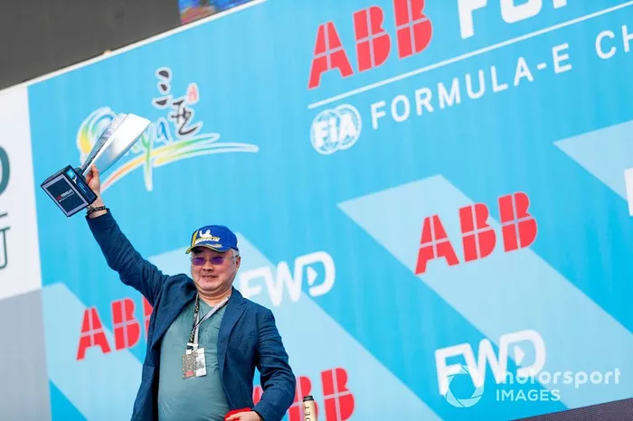 A DS TECHEETAH representative on the podium with the winner's trophy