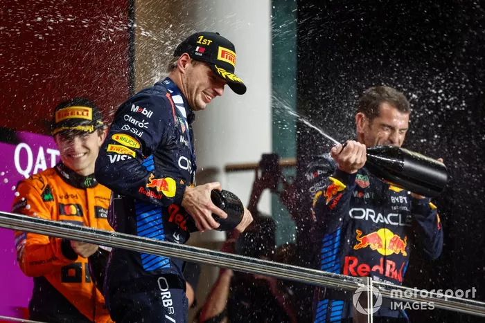 Max Verstappen, Red Bull Racing, 1ère position, Oscar Piastri, McLaren F1 Team, 3ème position, le délégué Red Bull Racing sur le podium arrose le champagne pour célébrer.