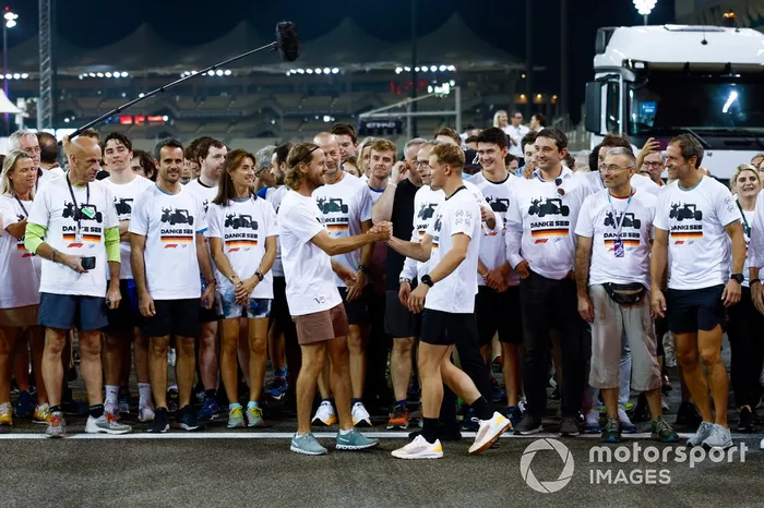 Sebastian Vettel, Aston Martin, es acompañado en una carrera alrededor del circuito por los miembros del equipo con la playera de Danke Seb como parte de su despedida en su último Gran Premio