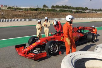 The Ferrari SF90 of Sebastian Vettel is recovered on a truck