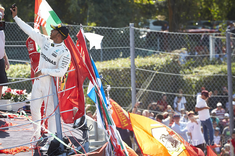 Race winner Lewis Hamilton, Mercedes AMG F1, takes a photo from the podium