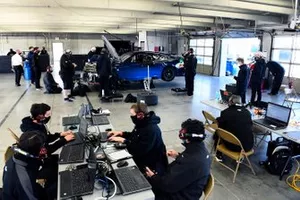 Team members make adjustments to the Nascar Next Gen car