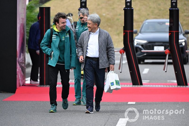 Fernando Alonso, Aston Martin F1 Team, llega al paddock con Masashi Yamamoto, asesor de Red Bull