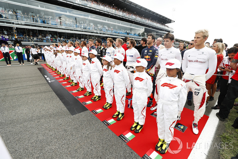 The Grid Kids y los conductores representan el himno nacional en la grilla