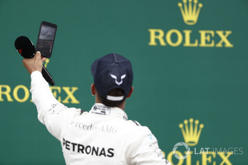 Podium:  Race winner Lewis Hamilton, Mercedes AMG F1, takes a photo, the crowd in the background