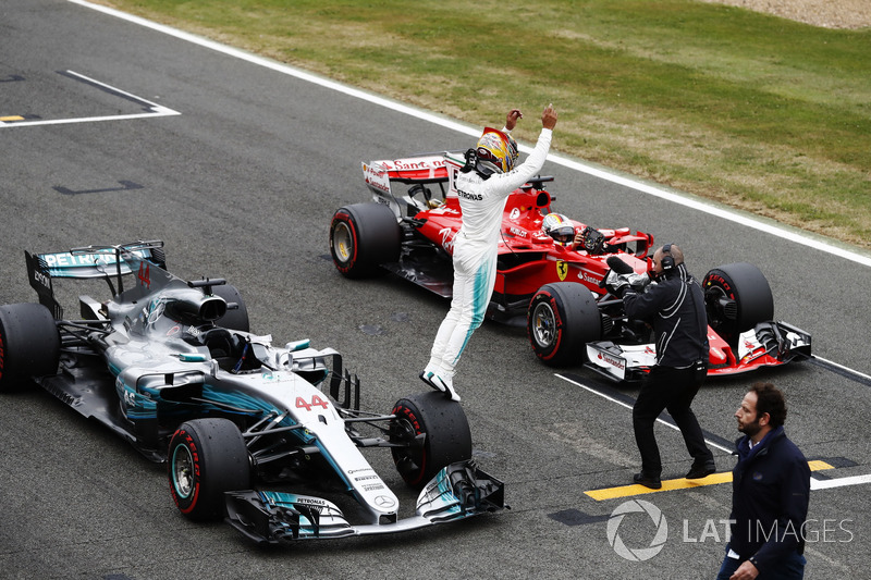 Lewis Hamilton, Mercedes AMG F1 W08, jumps off his car in celebration of pole position, alongside Sebastian Vettel, Ferrari