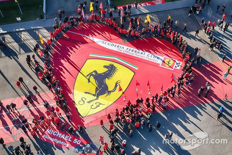 Прапор Ferrari, який тримають уболівальники, перед музеєм Ferrari, де розгорнута виставка "Міхаелю 50"